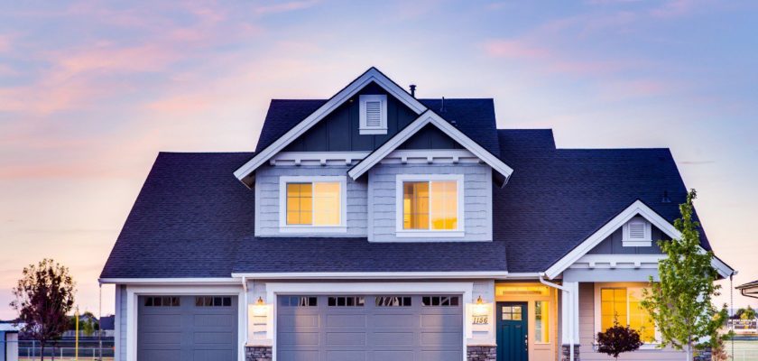 A large, two story home sits in front of a blue sky. The best HVAC for large homes depends on multiple factors.